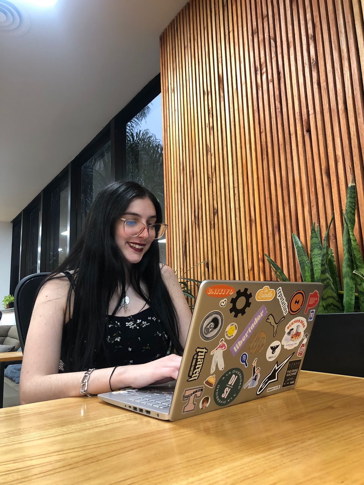 Luz Pastori, community developer de sede Libertador sentada en una mesa de trabajo con su notebook